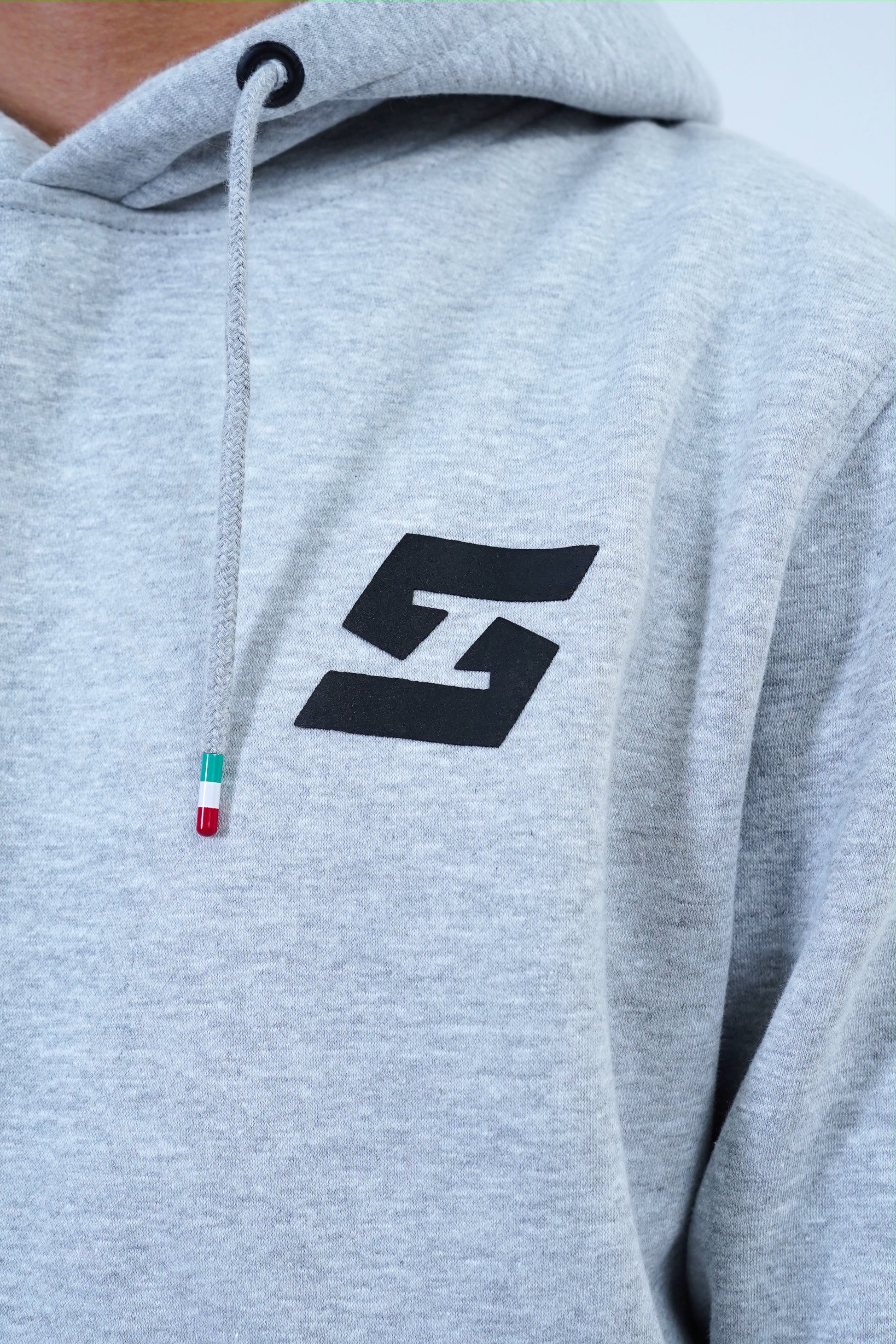 Gray pullover hoodie with black logo, featuring drawstring detail, part of men's jogger tracksuit set for casual and workout wear.